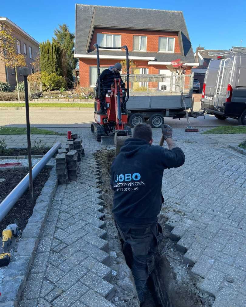 Rioleringswerken met minigraver in een woonstraat